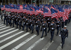 Members of the New York City Fire Department carry American flags as they march in the 253rd Annual Saint Patrick's Day Parade along 5th Avenue in Manhattan on Monday, March 17, 2014.