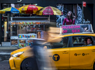 A pedestrian walks by a taxi with an advertisement for the Museum of Sex on it's roof in Midtown, Manhattan on Thursday, October 19, 2017. 