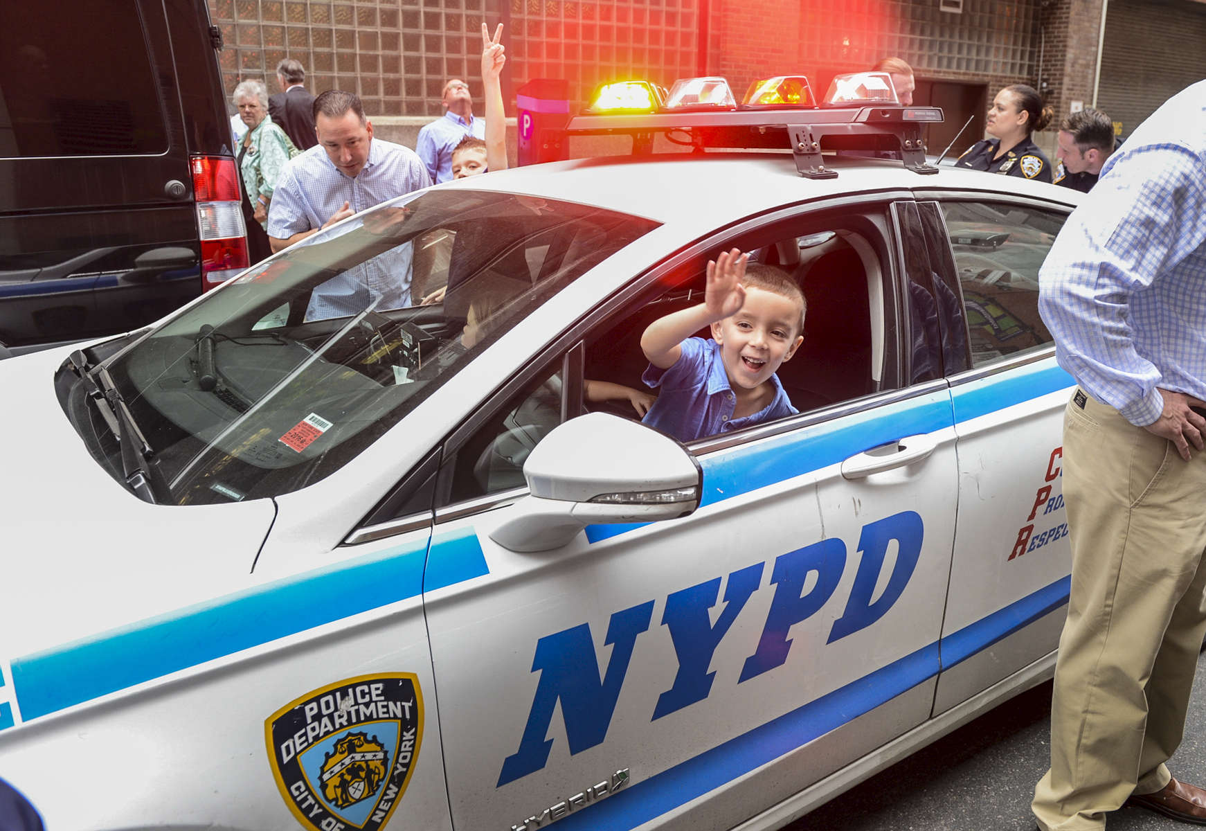 Robert (on the passenger side), Remi (on the middle inside) and Dean Dwyer (on the driver side) nephews and niece of NYPD Police Officer Anthony Dwyer, who in 1989 was pushed to his death off of a Times Square rooftop by convicted felon Eddie Matos, play inside an NYPD squad car after attending Eddie Matos' parole hearing on Friday May 13, 2016. 