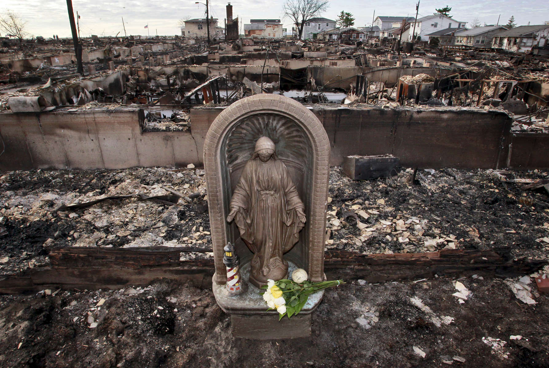 Flowers were laid in front of the statue of the virgin mary that survive the massive fire caused by hurricane Sandy in Breezy Point, New York on Friday,  November 2, 2012.