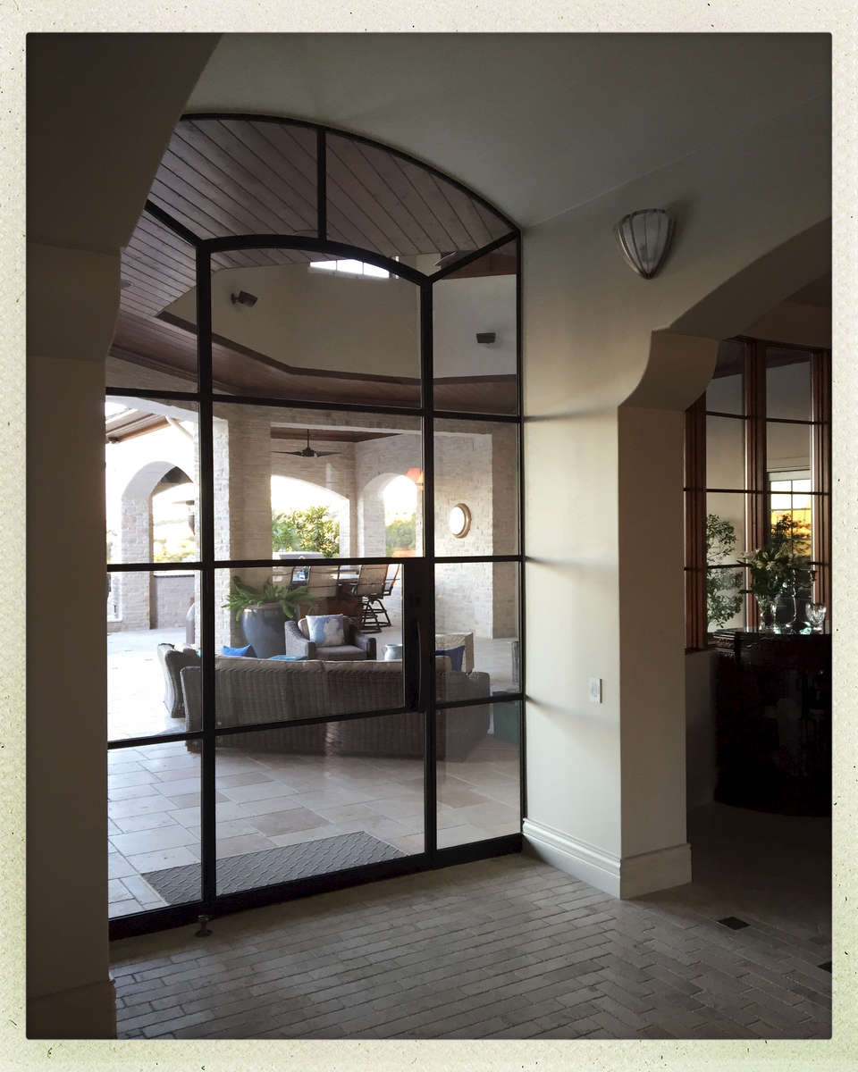 A regular doorway was redefined with a wall of glass from Portella.  The archway thresholds are accented with pewter.