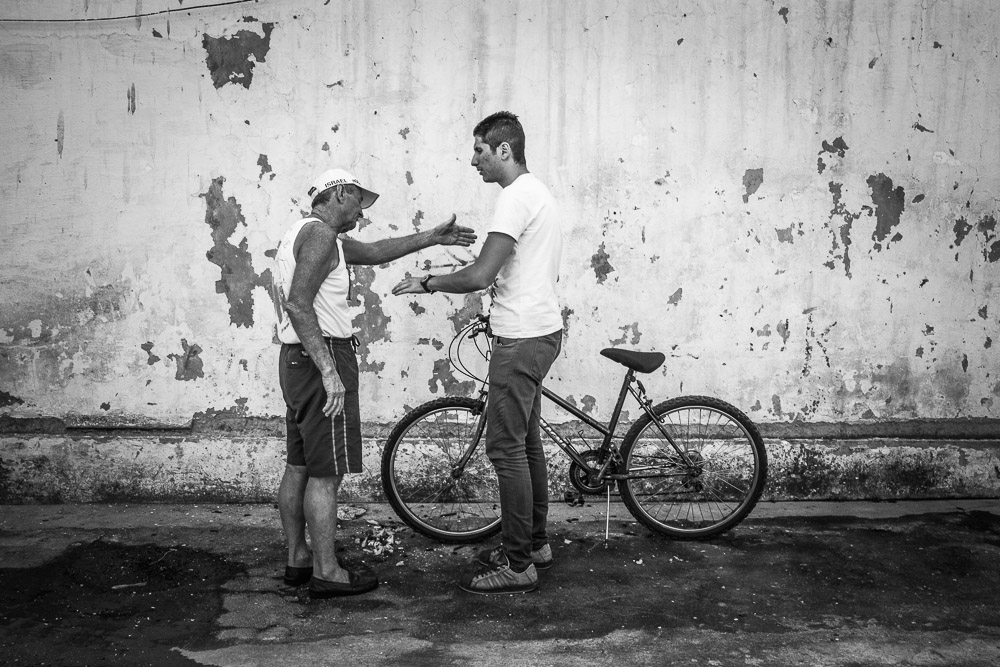 Syrian refugee, Armin argues with Brazilian man, wearing a Isreal cap about where to park his bicycle in the parking lot of Sao Joao de Bastista church in the commercial neighborhood of Botafogo in Rio de Janeiro.