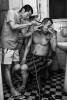 CAIRO, EGYPT - MAY 31 : Wu Qing Quan helps his brother in law Qing Gui cut his hair in their modest apartment shared with their wife's and many other Chinese street vendors on May 31, 2012 El Geish Square in Cairo, Egypt. 