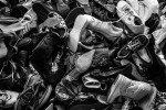 Donated shoes, are left unpaired on the top floors of a refugee non-for-profit. There is strangely always an abundance of adult supplies but a lack of children's clothes, alientation , canned and powder goods, such as milk. 