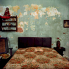 A cuban bedroom with walls of peeling paint due to the high humidity, and lack of air conditioning. Havana, Cuba