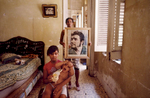 Chavela poses for her protrait while holding her cousin. Her mother, in the back, holds an image of Ernesto Che Guevara, who was a major figure of the Cuban Revolution, and has become a symbol of rebellion througout the world. Havana, Cuba
