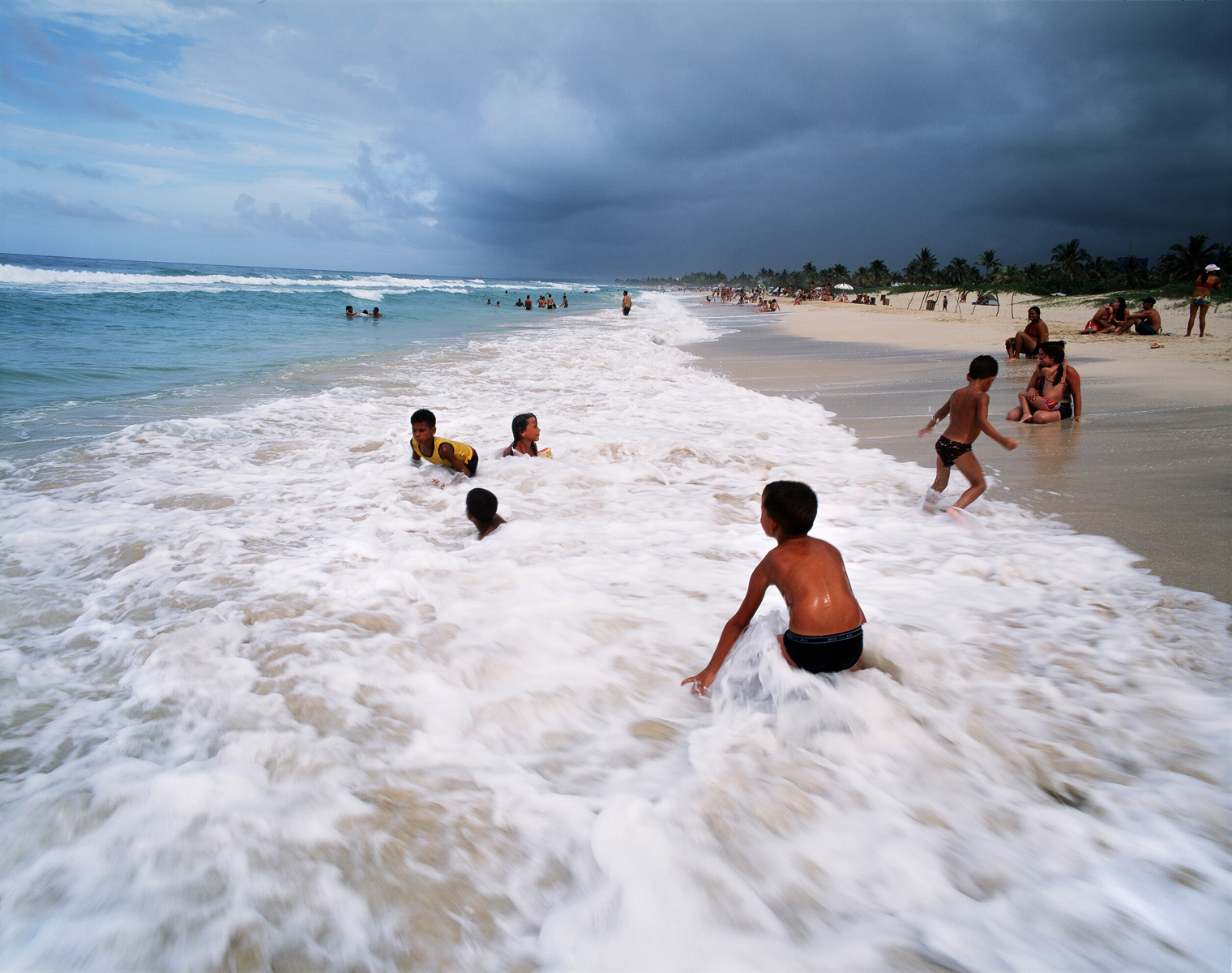 Children playing in the waves at Playa del Este, a popular beach for Cubans, 45 minutes east of Havana province. Playa del Este, Cuba