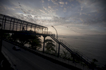 Residents of the shantytown of Vidigal crossing a bridge over the road of Niemeier on their way to work in Rio de Janeiro, Brazil, February 13, 2012. Initiated in 2008, the UPP, short for Unidade de Polícia Pacificadora (in English, Pacifier Police Unit or Police Pacification Unit), is a new system of community policing in Rio de Janeiro’s favelas once run by drug traffickers. While many believe that UPPs have helped quell violence by opening the doors of the favelas to public services such as legal electricity supply, garbage collection, education, public works and social assistance program, others see the pacification program as a temporary cover-up to security problems in Rio de Janeiro. 