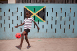 Kid playing Soccer in the neighborhood of Trenchtown, in Kingston, Jamaica