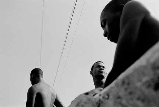 Young Haitian and Dominican boys relax on a bridge just over the Haiti-Dominican Republic border. Many Haitians cross the border into the DR to find better paying manual labot jobs. Once there, however, they often endure police harassment and discrimination. 2004