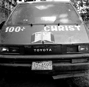 While Vodou is practiced by many in Haiti, most Haitians identify as Christian. Here a spiritually powered taxi attests to a vibrant Christian community in Cap-Haitien. Haiti 2004 