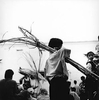 A young Hindu boy carries a bundle of sugar cane that will be used as an offering on the banks of the Ganges River.Varanasi, India 1997