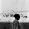 A woman walks in front of graffiti reading: {quote}Long live a free Haiti{quote}. The world's first independent black republic, Haiti broke the yoke of French rule in 1803. Cap-Haitien, 2004