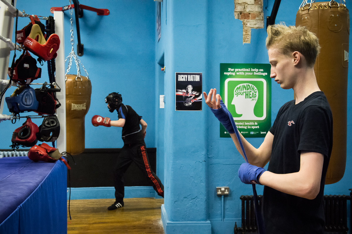 Joel, 15, wraps his hands with bandage before boxing practice at the City of Belfast Boxing Academy located on the Protestant side of the peace wall separating the small Catholic enclave Short Strand from the rest of the Protestant east Belfast. The boxing gym is located exactly on a peace line and although the gym is open to boxers from both communities, it's almost exclusively attended by young people from the Protestant side of the wall.