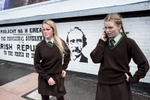 After school, Tigernach (right), 14 and her friend Dawn, 13, wait for a green traffic light to cross the road in the Catholic Falls road area of west Belfast. Behind them a mural commemorating the 1916 Proclamation of the Republic, a document written in the name of the self-styled Provisional Government of the Irish Republic that proclaimed Ireland's independence from the United Kingdom.