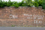 Graffiti threatening heroin dealers on a wall in the Catholic Falls area of west Belfast. The graffiti is signed by Oglaigh na hEireann (ONH) - soldiers of Ireland - a small dissident republican paramilitary group.Paramilitary activity is an enduring legacy of the Troubles. Paramilitary groups  are involved in drug trafficking, protection rackets and other criminal activities. The paramilitary groups continue to recruit young people, often through coercion or in payment for drug debts. They also engage in vigilante policing and pretend to protect their communities from alleged anti-social behavior and petty crime with their violent attacks. People, including children, from both communities have to cope with the intimidations, beatings, shootings and expulsions out of the area by the paramilitaries of their own community.