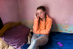 Stephanie, 19, sits on her bed in her aunt's home in the Protestant Oldpark area of north Belfast where she lives temporarily. Her father and uncle were very active in the UDA (Ulster Defense Association), a loyalist paramilitary group. Stephanie stopped going to school at 14 because of drug use and struggled until very recently with a drug addiction. She finds it tough to live with the family history. {quote}People look different at me. I carry the name {quote} she said {quote}If I hadn't been strong, I would have been death long ago{quote}.