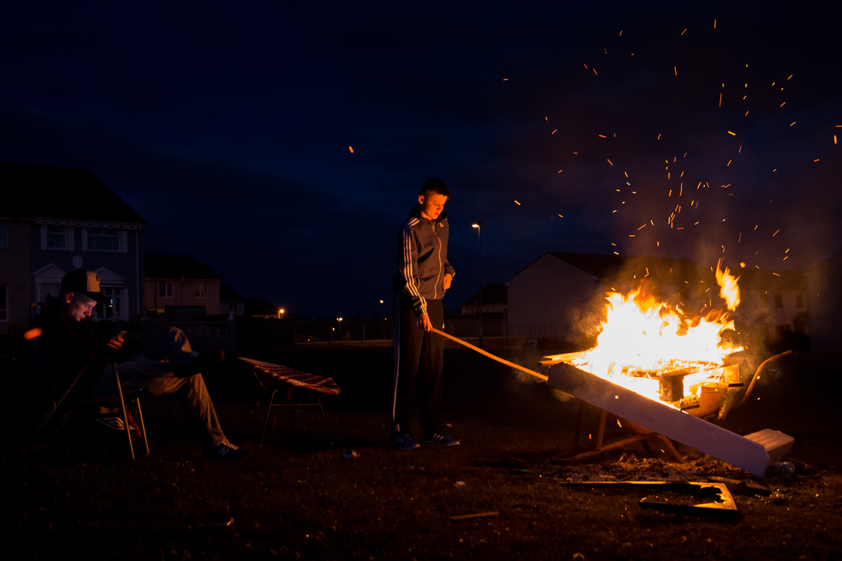 Young people hang out around a fire in the Protestant Lower Shankill area of west Belfast. As the widespread unemployment has become normalized for them, many young people have very low aspirations.