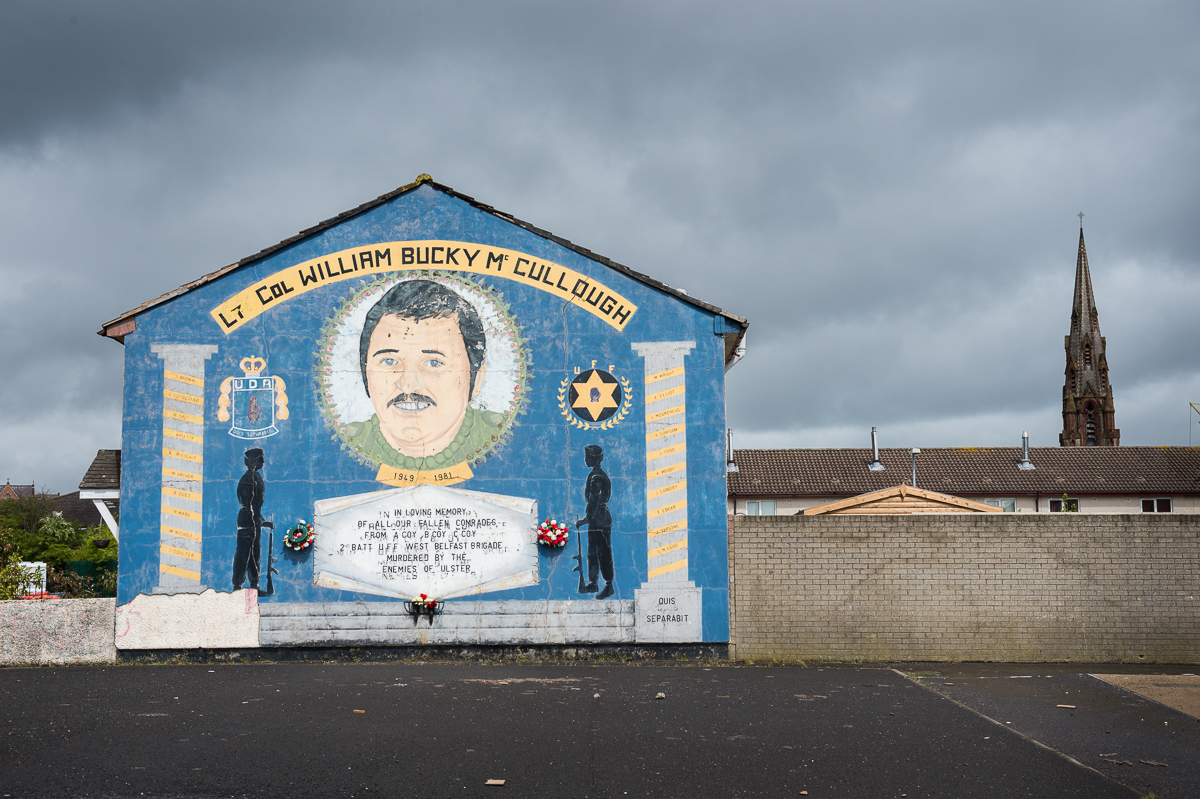 A UDA/UFF paramilitary mural in the Protestant Lower Shankill area of north Belfast honoring a killed member.  The paramilitary group UDA (Ulster Defense Association) whose slogan is {quote}QS{quote} (Quis Separabit)  - who will separate (us) - was proscribed as a terrorist organization in 1992. Earlier on, in 1973 the UFF (Ulster Freedom Fighters), a cover name used by the UDA when conducting operations, was outlawed. UDA/UFF terrorists were responsible for hundreds of deaths, most of them Catholic civilians, during the Troubles. Now, the  UDA/UFF has evolved into a criminal organization engaged in drug trafficking, protection rackets and other criminal activities. And like the other paramilitary groups in Belfast, they are also involved in vigilante activities and pretend to protect their communities from alleged anti-social behavior and petty crime with their violent attacks. People, including children, from both communities have to cope with the intimidations, beatings, shootings and expulsions out of the area by the paramilitaries of their own community.
