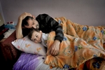 Thirty-year-old Mehmet Çalis lies in bed with his nephew Faruk.  Before becoming ill with silicosis at the age of twenty-four, Mehmet worked for less than one and a half year in the sandblasting industry.