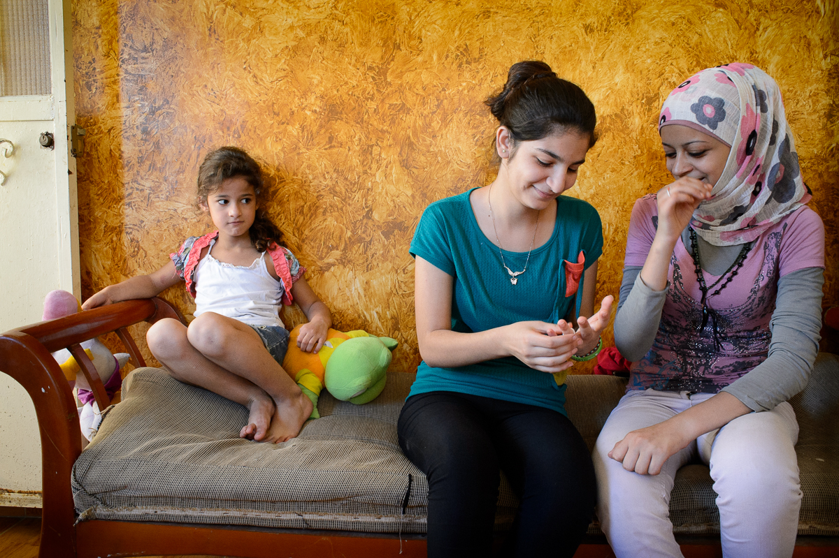 Amneh Dawoud (14) and Nirmeen Hazineh (15) talk  while a cousin looks on. Amneh, a Palestinian refugee from Syria, can no longer go to school .