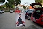 Father-manager Angelo rolls up a poster of Sasà (11). The boy started singing less than a year ago; since then he has recorded a CD and sang at many events. His father promotes him as the new voice from Naples.