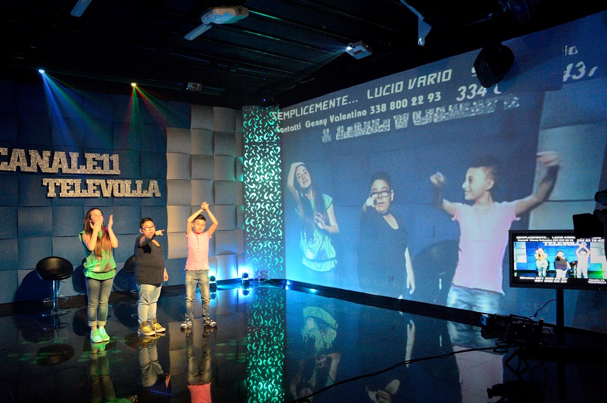 Televolla is one of the many TV stations consecrated to neomelodica music. Here Lucio (12), Sasà (11) and Melissa (13) are seen lip-synching a song on a show where viewers call in dedications and requests.