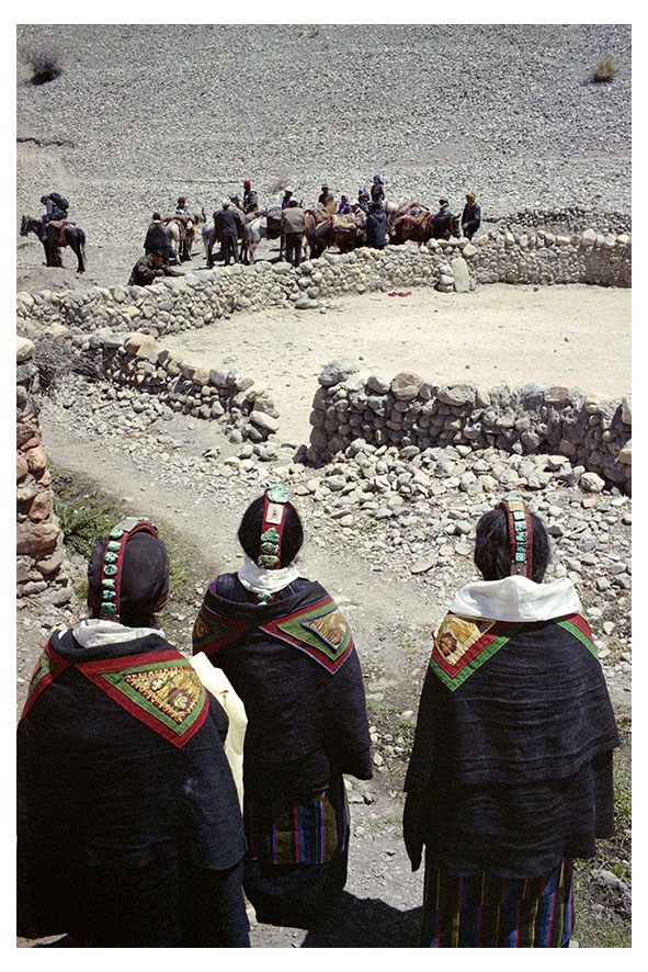 Women watching family and friends leave the village. Tangye, Mustang region, Nepal, April 2009.