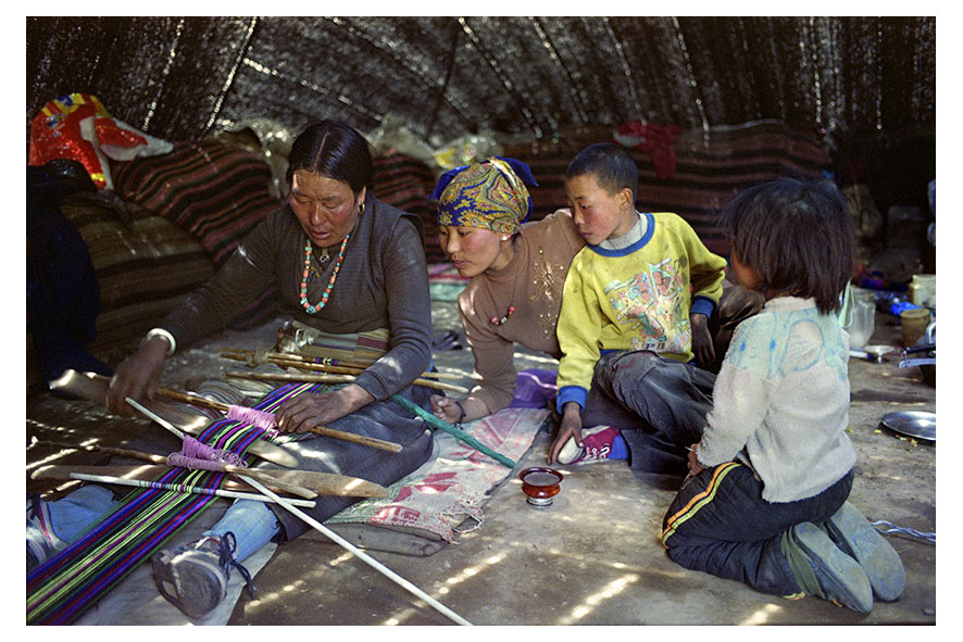 Nomad family. In the afternoon, chhiten teaches diki how to weave traditional belts, under the curious eye of tsering and the neighbours’ son. It takes 4 to 5 days to make a belt. If she does not keep it for herself, she will sell it in town for 1000 rupees or $8. Mustang region, Nepal, April 2009.