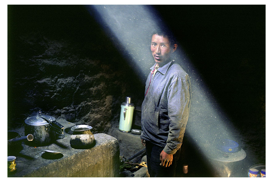 Tangye, 11,400 feet is the oldest village in mustang. Njawan nyima in his kitchen preparing dinner. Njawan, 26, owns and works on one arcre of land. He grows cereal, potatoes and apples. Njawan earns 12,000 rupees a month – $100 – which allows him to provide for his wife, three year-old son and his mother that lives with them. Mustang region, Nepal, April 2009.
