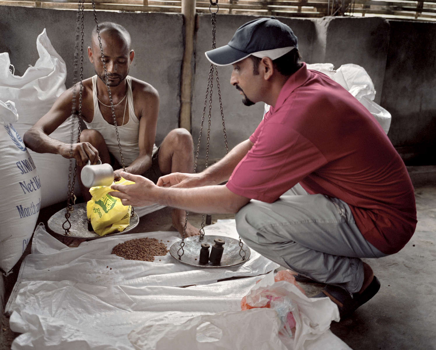 Rabi venant chercher la ration de nourriture pour sa famille. Chaque 15 jours les réfugiés viennent chercher les rations de nourriture distribuées par le World Food Programme (WFP). Cela comprend du riz, du sel, de l'huile, des lentilles, quelques légumes et des céréales. Népal, 2009.