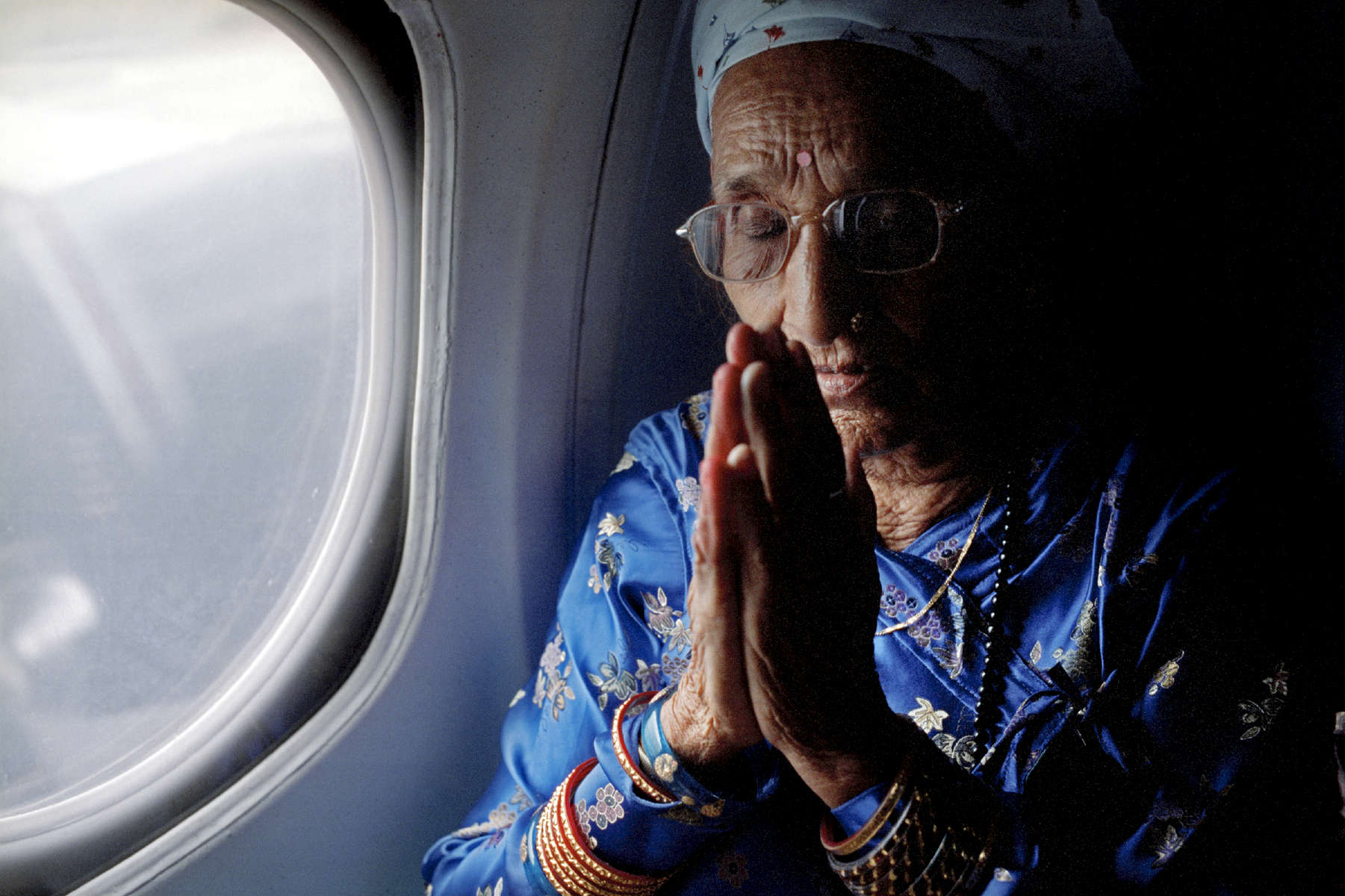 Radika s baptem. Radika mainali, in a plane for the first time in her life, praying before they take off. August 2009.