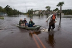 David Carroll (R) of Waccamaw Lake Drive, carries via boat, neighbors Rick Woodward, Miki Woodward and Matt Desjardins in Conway, South Carolina October 6, 2015. The Woodward family came to the landing from their flooded neighborhood to meet daughter Kelly who had been separated from them for a few days because of the floods. Floodwaters from unprecedented rainfall in South Carolina have killed 11 people, closed some 550 roads and bridges and prompted hundreds of rescues of people trapped in homes and cars, officials said on Monday. REUTERS/Randall Hill
