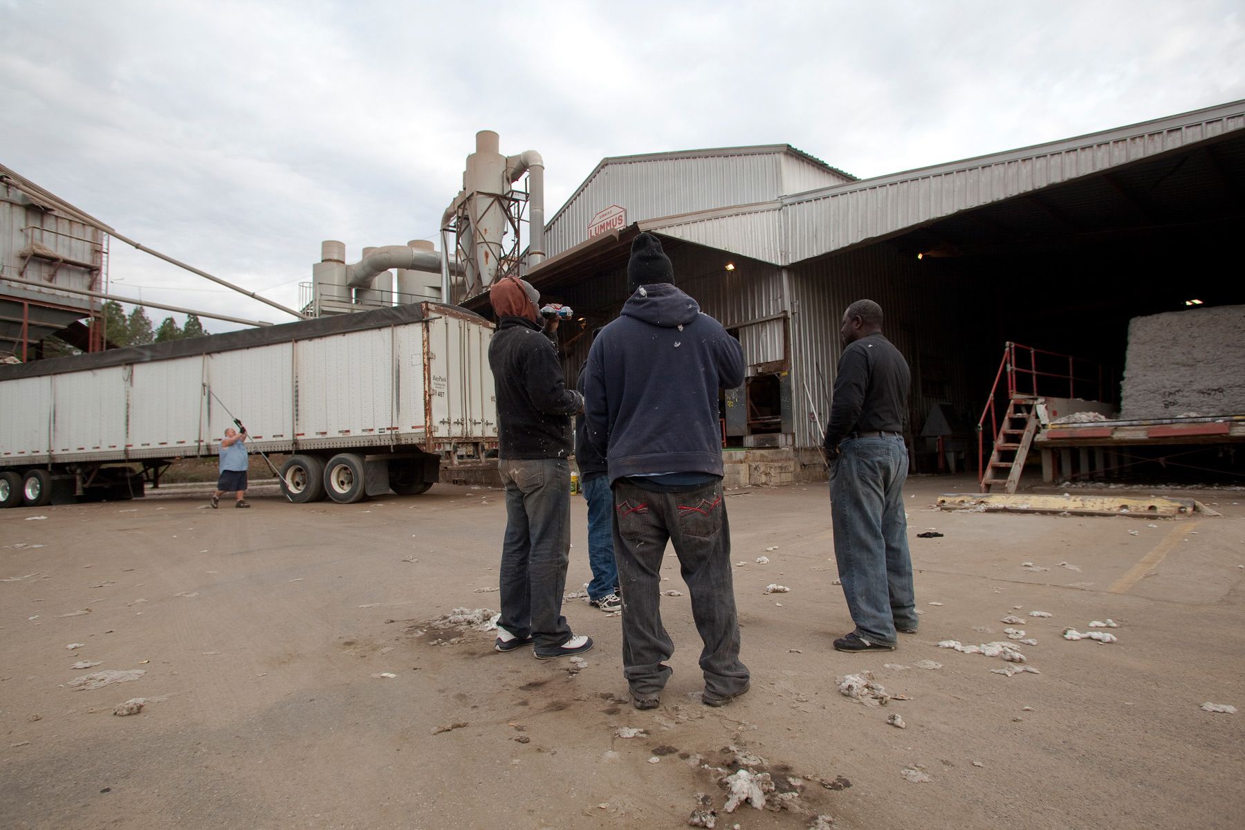 Baggers stand outside the Minturn Cotton Company during a break in production in Minturn, South Carolina November 27, 2012. The facility gins cotton after it is harvested to remove the seeds and clean the cotton for shipment. About 80 percent of the cotton ginned at this facility is exported outside the U.S.    REUTERS/Randall Hill (UNITED STATES)