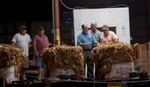US Tobacco graders Jimmy Allen (third from left) and Scott Harrington, discuss a tobacco grade with warehouse manager Elton Johnson at the Big L Warehouse in Mullins, South Carolina July 29, 2013. The farm cooperative US Tobacco sets the standard for pricing and quality of the area farmer's crops at this warehouse. The traditional tobacco harvest requires many labor intensive hours to bring the crop to market, especially with the flue-cured variety prominent in the southern United States. With the growing health concerns with smoking in the US, most farmers use market cooperatives to sell their crop to the growing markets in China.      Picture taken on July 29, 2013.   REUTERS/Randall Hill (UNITED STATES)