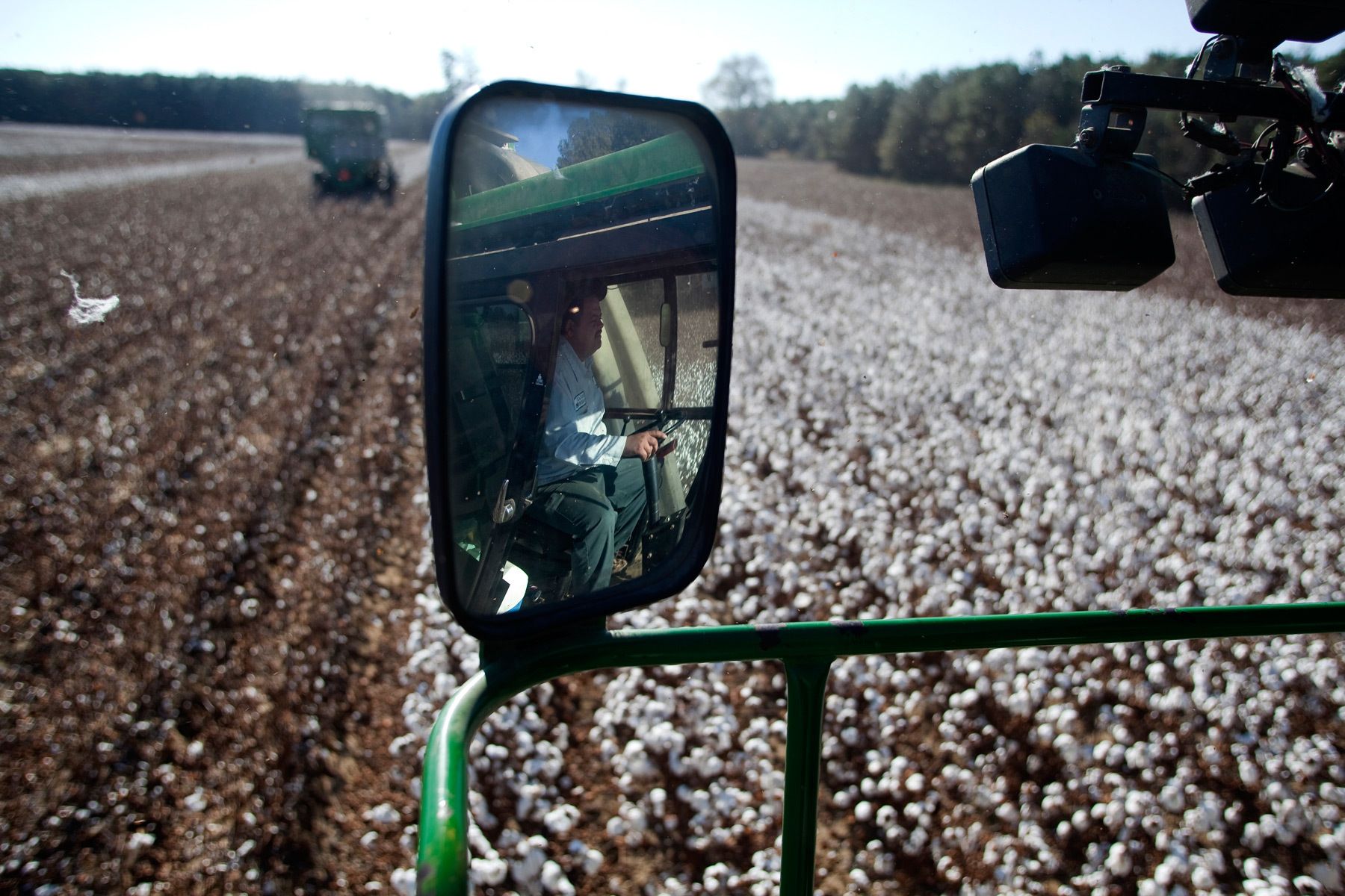 Operator James Grooms is reflected in the mirror of a cotton picker at Baxley & Baxley Farms in Minturn, South Carolina November 24, 2012. The third generation farm, located along South Carolina's cotton corridor, harvested just under 1100 acres of cotton this season. The Baxley family plants several crops but cotton is the cash crop and the most profitable.    REUTERS/Randall Hill (UNITED STATES)