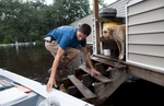 Michael Carroll checks on his dog Bailey on flood covered property in Conway, South Carolina October 6, 2015. The Carroll family has been living with several feet of water on their land since Saturday. Floodwaters from unprecedented rainfall in South Carolina have killed 11 people, closed some 550 roads and bridges and prompted hundreds of rescues of people trapped in homes and cars, officials said on Monday. REUTERS/Randall Hill