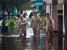 Norman Beauregard, (From Left) Kevin Attender and Chris Rogers, all with the Georgetown Fire Department, wade through flooded Front Street in Georgetown, South Carolina October 4, 2015. Most major roads through the historical South Carolina city have closed due to flooding. Vast swaths of U.S. Southeast and mid-Atlantic states were grappling with heavy rains and flooding from a separate weather system which has already caused at least five deaths, washed out roads and prompted evacuations and flash flood warnings. REUTERS/Randall Hill