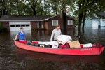 Greg Rodermond (R) and Mandy Barnhill, use a canoe to evacuate Mandy's home on Long Avenue in Conway, South Carolina October 5, 2015. Torrential rainfall that South Carolina's governor called a once-in-a-millennium downpour triggered flooding in the southeastern U.S. state on Sunday, causing at least eight deaths in the Carolinas. The storm had dumped more than 20 inches (50 cm) of rain in parts of central South Carolina since Friday, the National Weather Service said. The state climatologist forecast another 2 to 6 inches (5 to 15 cm) through Monday as the rain began to slacken. REUTERS/Randall Hill