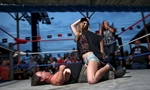 A woman competes in a competition with midget wrestler Joe Kidd  May 19, 2012 at the biker bar Suck Bang Blow in Murrells Inlet, S.C.  The midget troupe of wrestlers performed nightly during the annual Harley-Davidson Motorcycle Spring Rally around Myrtle Beach, SC. Several motorcycle rallies are annual events in and around the southern resort community of Myrtle Beach. Later this week events starts for the Atlantic Beach Bike Fest in nearby Atlantic Beach.  Picture taken May 19, 2012.  REUTERS/Randall Hill
