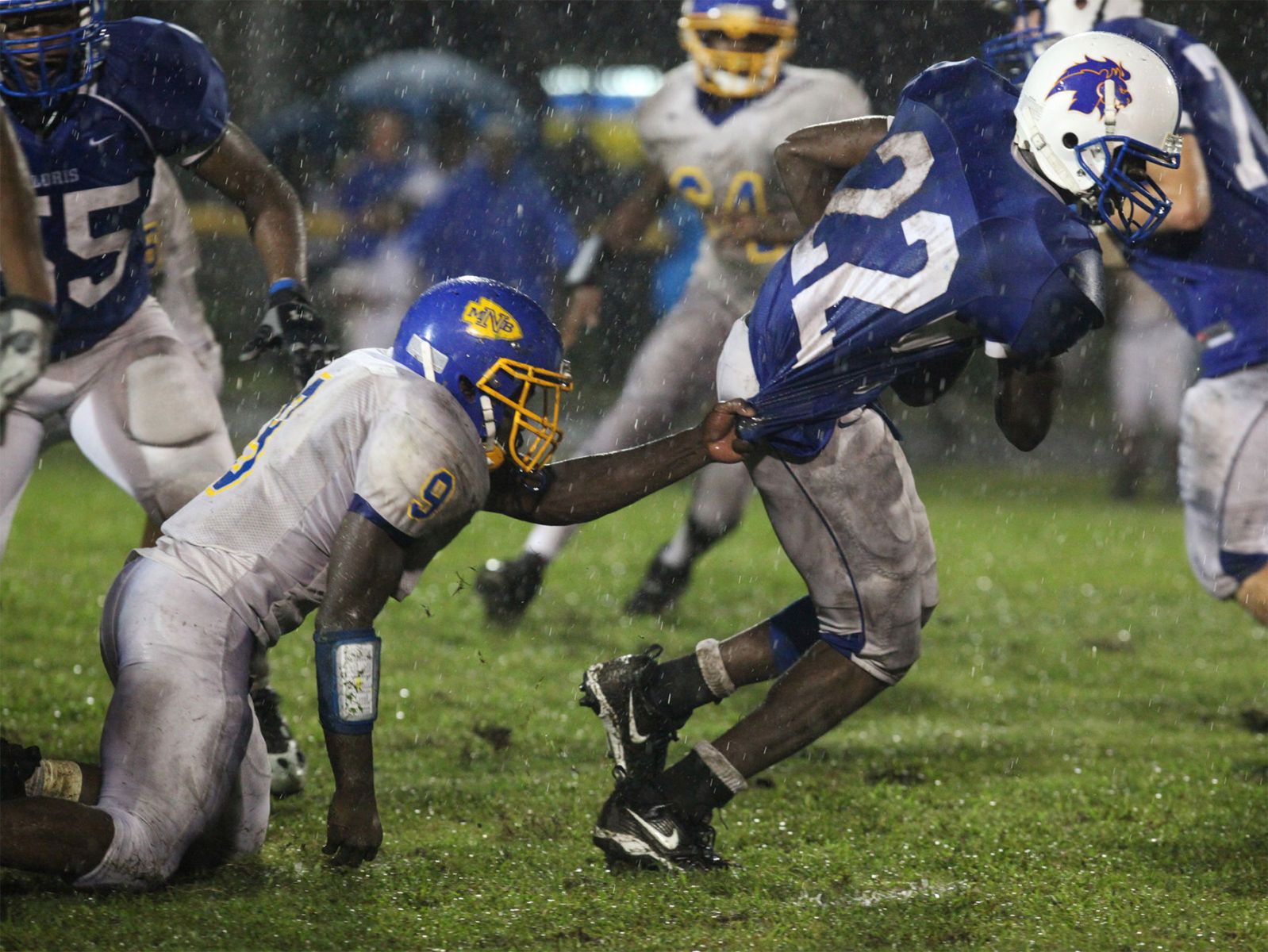 North Myrtle Beach defender Kelton Chestnut, 9, holds on to the jersey of Loris running back R.J. Brown, 22, during 4th quarter action during the Chiefs 14-6 win over cross county rivals Loris Friday night at Heniford Stadium in Loris. The teams played in a constant downpour throughout the second half of the game as the battle of supremacy of northern Horry was determined by the defense of the two teams.
