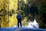 Horry County police officer Jeff Helfinstine patrols the edge of flood waters along Lee's Landing Circle in Conway, South Carolina October 7, 2015. Rescuers searched early Wednesday for two people missing in floodwaters in South Carolina, while authorities urged residents in hundreds of homes to seek higher ground. REUTERS/Randall Hill